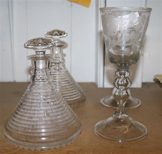 A pair of wheel-engraved glass goblets and a pair of ships decanters